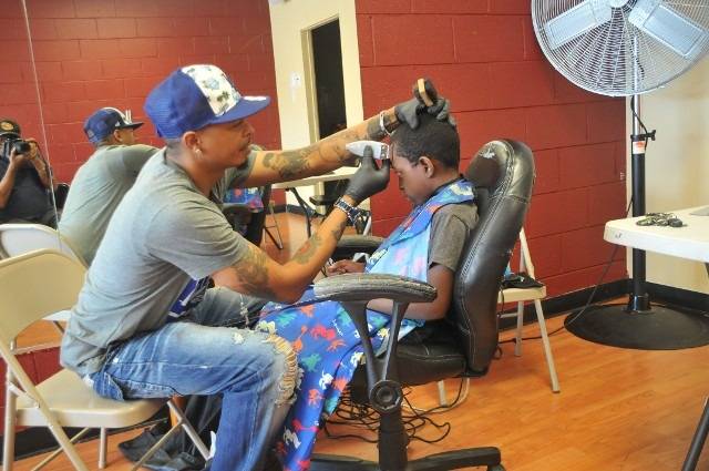 Barber giving a boy a haircut in a salon.