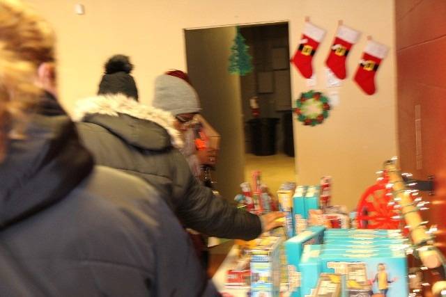 People shopping for toys near Christmas decorations.