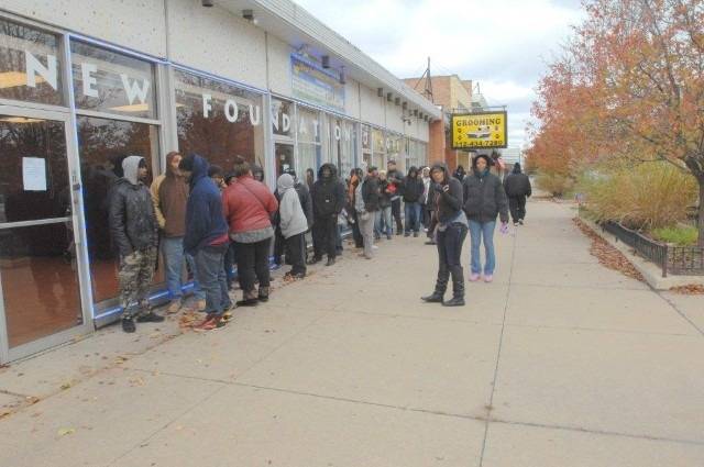 People standing in line outside a storefront.