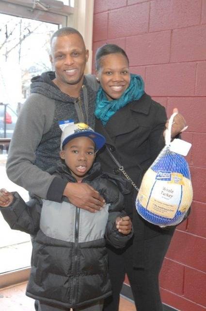 Family with whole turkey smiling at camera