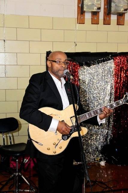 Guitarist playing and singing into a microphone