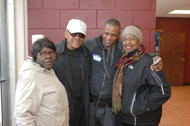 Four smiling people posing for a group photo.