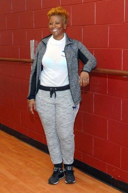 Woman wearing athletic clothes smiling.