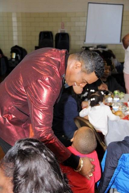 Man in shiny red jacket with child at a party