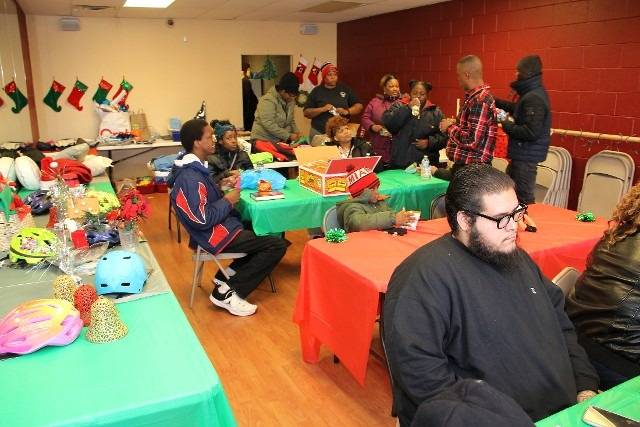 A social gathering with people sitting at tables, decorated for the holidays.