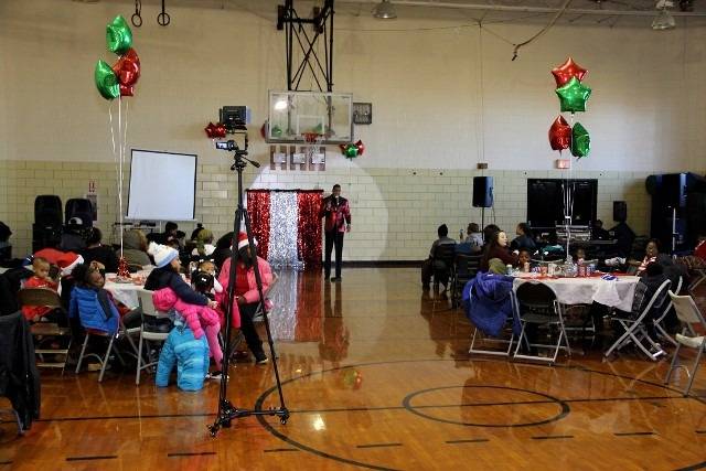 Christmas party in a gym with balloons and tables.
