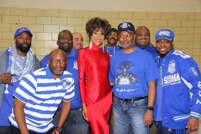 Group of men with a woman pose for a photo.