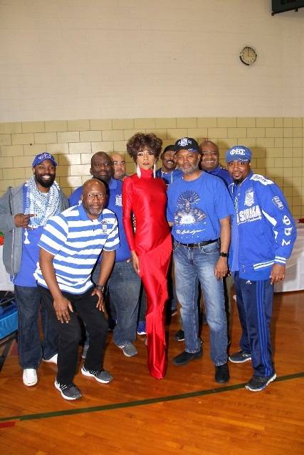Group photo with a woman in red dress, men in blue.