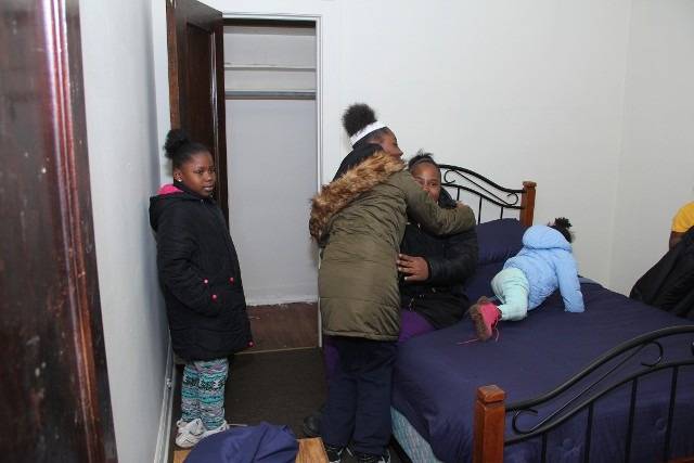 Family in a room hugging each other.