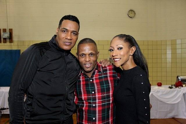 Three smiling people pose for a photo at an event.