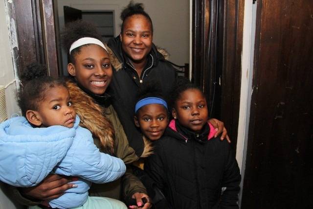 A family of five poses for a photo indoors