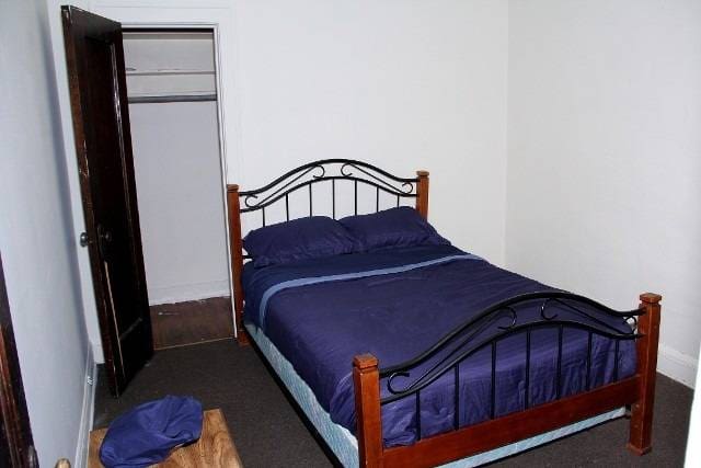 Bedroom with dark wood bed and closet.