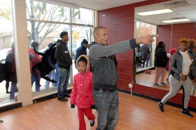 People in a dance studio with one man pointing.