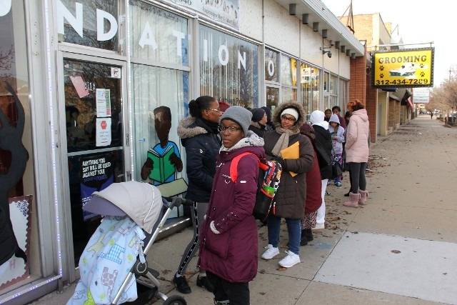 People waiting in line outside a storefront