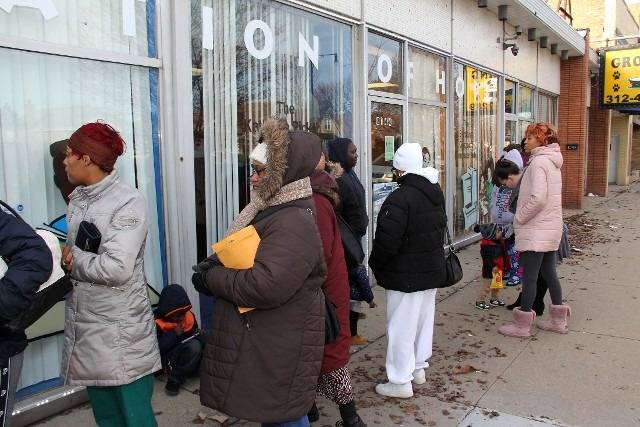 People waiting outside a building.