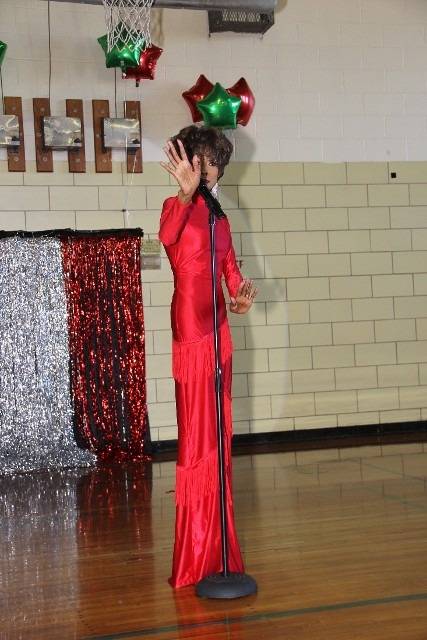 Person in red dress performing with microphone.