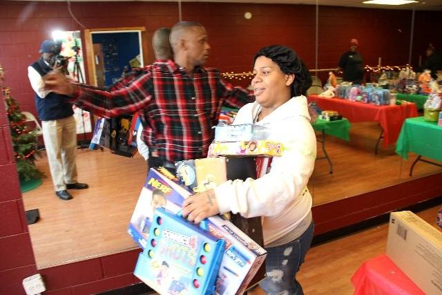 Woman carrying a stack of toys for gift-giving.